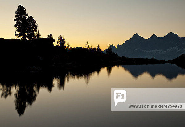 Berge und Baum spiegeln sich im See im letzten Abendlicht  Reiteralm  Spiegelsee  Steiermark  Österreich  Europa