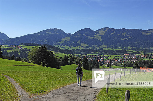View of Fischen  hiker on a hiking trail in the foreground  Allgaeu Alps at the back  Schoellang  Allgaeu region  Bavaria  Germany  Europe