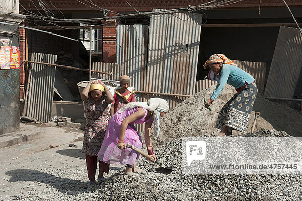 Harte körperliche Arbeit  Bauarbeiterinnen schippen Kies mit Schaufeln  Durbar Square  Kathmandu  Kathmandutal  Himalaja  Nepal  Asien