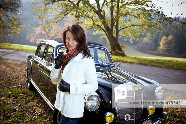 Junge Frau vor einem Mercedes aus der Nachkriegszeit  Oldtimer