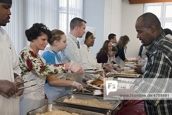 Students from Dorsey Culinary School serve a meal to homeless persons and supporters gathered at the Cathedral Church of St. Paul for Homeless Persons' Memorial Day  remembering homeless persons who have died in the last year  Detroit  Michigan  USA