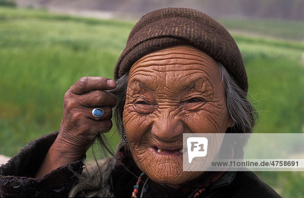 Porträt einer vom harten Leben gezeichneten freundlichen  älteren Frau  an ihrer Hand ein Ring mit einem Türkis  Zanskar Ladakh  Himalaya  Nordindien  Indien  Asien