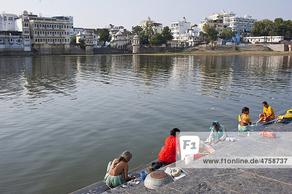 Indian women washing their laundry on the shore  Ghat  Lake Pichola  Udaipur  Rajasthan  India  Asia