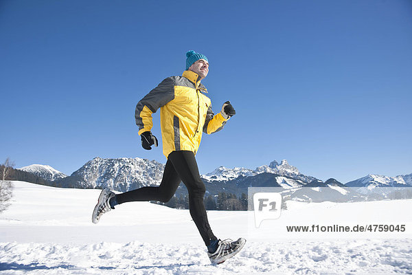 Man jogging in snow  Tannheimer Tal  Tyrol  Austria