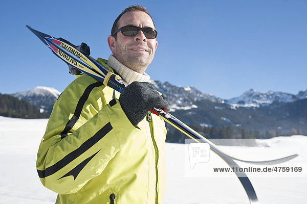 Mann mit Skiern in Winterlandschaft  Tannheimer Tal  Tirol  Österreich
