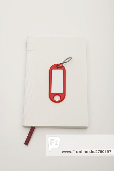 Notebook and key tag  symbolic image for searching for an apartment