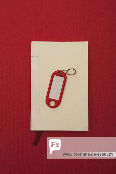 Notebook and key tag  symbolic image for searching for an apartment