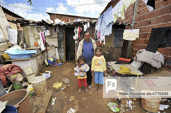Schwangere Frau  43  lebt mit zwei Töchtern vor einer ärmlichen Baracke in einer Favela  Armenviertel  die Familie lebt vom Sammeln  Trennen und Verkauf von Müll  der für Recycling bestimmt ist  Satellitenstadt Ceilandia bei Brasilia  Distrito Federal  Brasilien  Südamerika