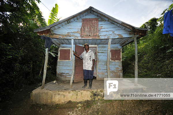 Mann vor seinem traditionellen Holzhaus das durch das Erdbeben im Januar 2010 stark beschädigt wurde  Dorf Coq Chante nahe Jacmel  Haiti  Karibik  Zentralamerika Holzhaus