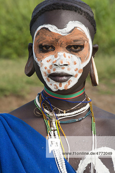 Junge Surma Frau mit Gesichtsbemalung und Körperbemalung und Ohrläppchenteller  Kibish  Omo-Tal  Äthiopien  Afrika