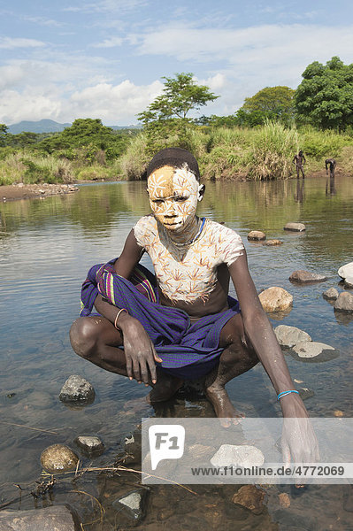 Surma Junge mit Gesichtsbemalung und Körperbemalung im Fluss  Kibish  Omo-Tal  Äthiopien  Afrika