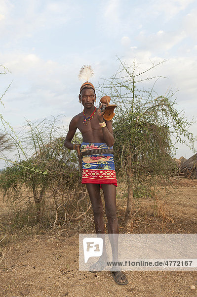 Hamar Krieger mit typischer Lehm Haarfrisur und Feder  mit Gewehr und Kopfstütze  Omo-Tal  Süd Äthiopien  Afrika