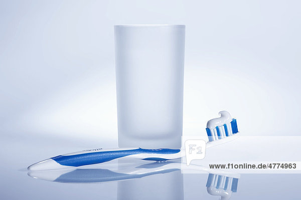 Blau weiße Zahnbürste mit Wasserglas