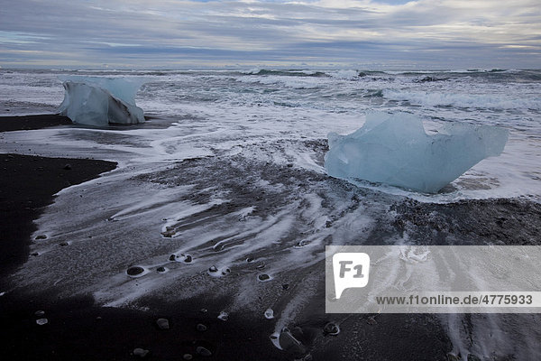Das Meer umspült Eisblöcke am Strand  Jökulsarlon  Island  Europa