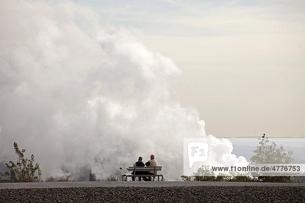 Couple on a bench in front of air pollution from a power plant in Bottrop  Ruhr Area  North Rhine-Westphalia  Germany  Europe