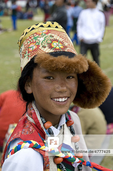 Tibeter  Junge in tibetischer Tracht mit großer Mütze  Portrait  Lächeln  Festival in Choklamsar bei Leh  Region Ladakh  Bundesstaat Jammu und Kaschmir  Kashmir  Indien  Südasien  Asien