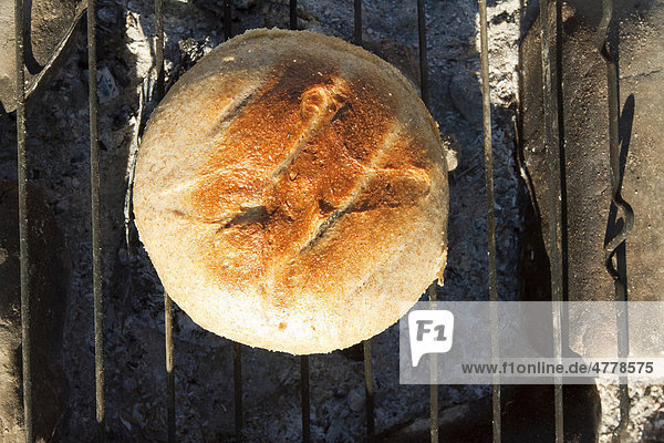 Brotbacken auf einem Lagerfeuer,  Brot bekommt eine Kruste indem man es aus dem Topf nimmt und einige Minuten auf den Grill legt,  Campen,  Wind River,  Yukon Territory,  Kanada