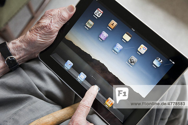 Senior betrachtet Bedienoberfläche auf seinem iPad  Nahaufnahme Hände