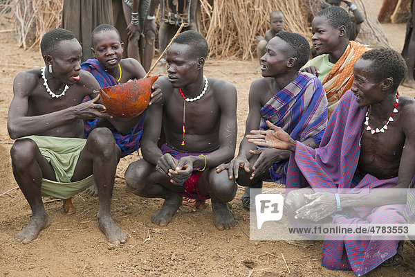 Nyangatom  oder Inyangatom Männer teilen sich eine Kalebasse Kuhblut  Omo-Tal  Äthiopien  Afrika