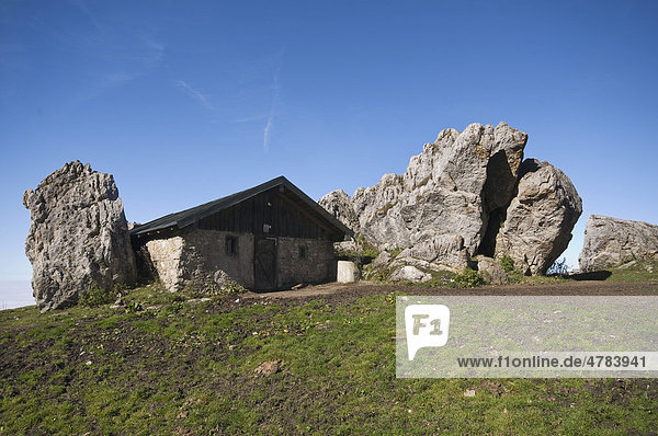 Steinhaus an der Steinlingalm neben großen Kalkstein-Felsbrocken  Kampenwandmassiv  Chiemgau  Kampenwand  Oberbayern  Bayern  Deutschland  Europa