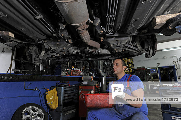 Mechanic at work  carrying out an oil change  garage