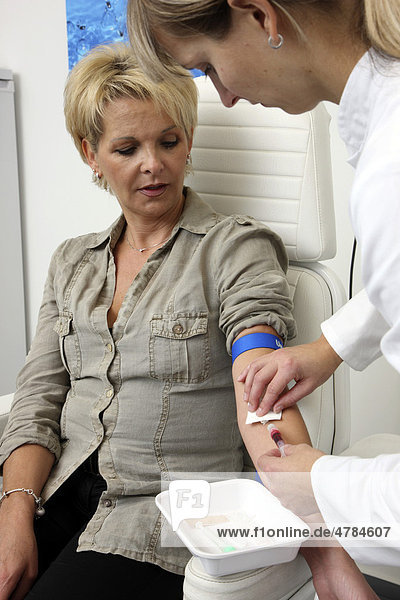 Arztpraxis  Blutabnahme zur Blutuntersuchung im Labor bei einer Patientin durch eine Praxishhilfe  medizinisch-technische Angestellte