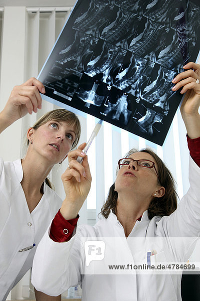 Medical practice  doctor and medical technician examining MRT images
