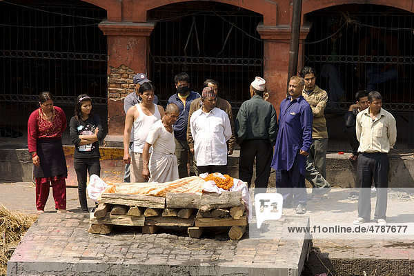 Teilnehmer eines traditionellen Begräbnis umstehen zur Verbrennung aufgebahrte Leiche eines Verwandten  Pashupatinath  Nepal  Asien