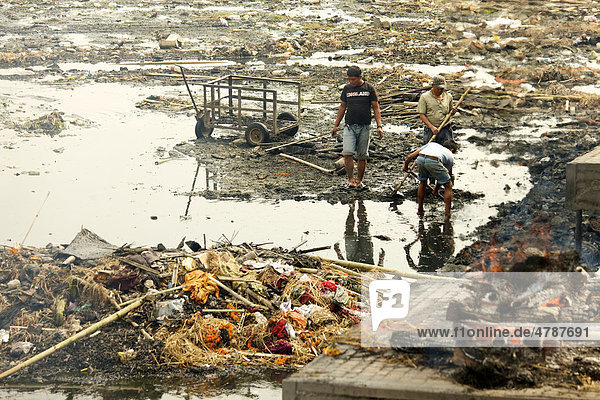 Brennender Scheiterhaufen und Müllsammler im verdreckten heiligen Fluss Bagmati  Pashupatinath  Nepal  Asien