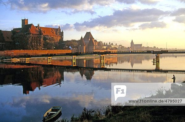 Morning mood with an angler on the Nogat River with Malbork Castle  formerly Marienburg Castle  the seat of the Grand Master of the Teutonic Knights  Malbork  Mazury  Poland  Europe