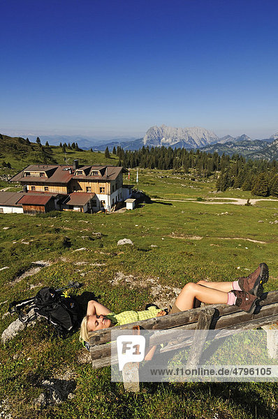 Wanderin ruht sich aus  Eggenalm beim Straubinger Haus  hinten der Wilde Kaiser  Reit im Winkl  Chiemgau  Oberbayern  Bayern  Deutschland  Tirol  Österreich  Europa