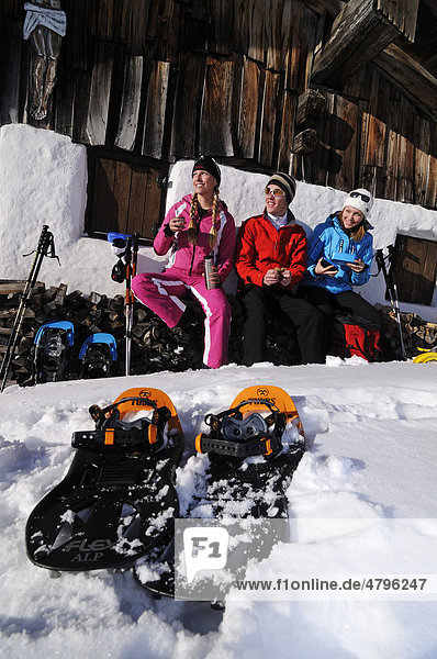 Snowshoers having a break while snowshoeing  Eggenalm alp  Tyrol  Tirol  Austria  Europe