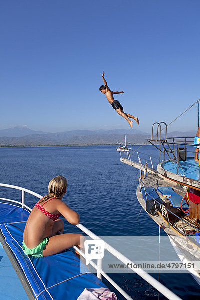 Teenager jumping from a boat  Red Island  Turkish Aegean  Turkey  Asia