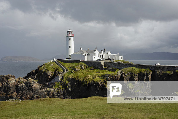 Fanad Head Lighthouse on rocky cliff  rain shower  County Donegal  Ireland  Europe