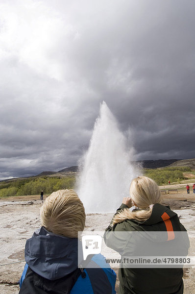 Tourists watching Strokkur Geyser erupting  Geysir  geyser  Iceland  Europe