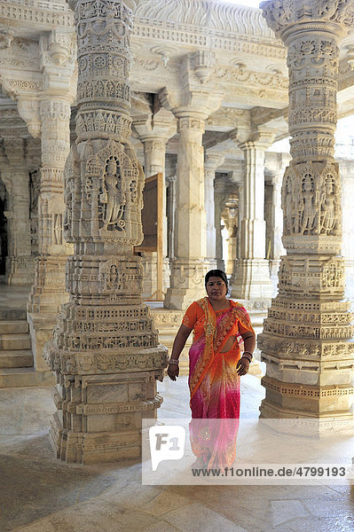 Indische Frau im traditionellen Sari in der Innenhalle mit kunstvoll verzierten Säulen im Marmortempel Ranakpur  Tempel der Jain-Religion  Rajasthan  Nordindien  Indien  Asien