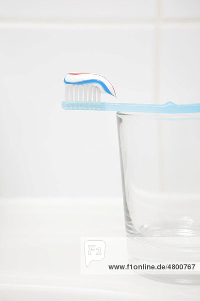 Zahnbürste mit Zahnpasta  Glas