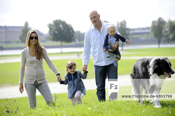 Glückliche Familie mit einem dreijährigen Mädchen  einem sechs Monate alten Jungen und einem Hund