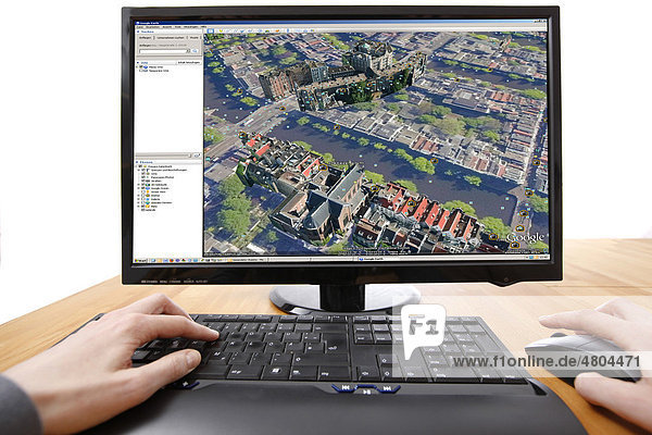 Person sitzt am Computer  arbeitet mit Google Street View  Übersicht von einem Teil der Innenstadt von Amsterdam