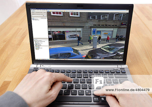 Person sitzt am Computer  arbeitet mit Google Street View  Detailbild von einem Teil der Innenstadt von Amsterdam  Personen sind erkennbar