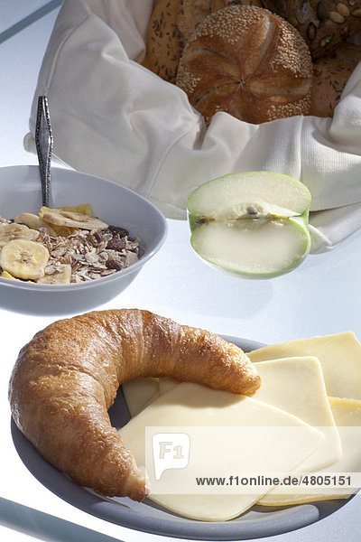 Gedeckter Frühstückstisch mit Kaffee  Brötchen  Müsli  und Apfel