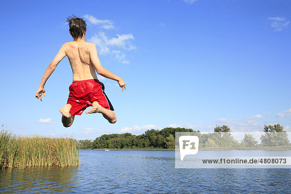 Boy jumping into Lake Teterower in Mecklenburg-Western Pomerania  Germany  Europe