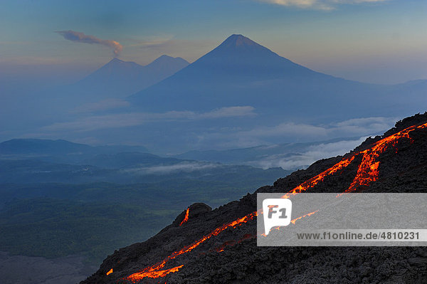 Active Pacaya volcano with lava flow in front of Agua and Fuego volcanoes  Guatemala  Central America