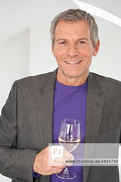 Reifer Mann mit Weinglas  lächelnd  Portrait