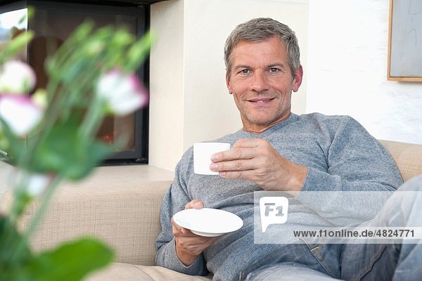 Erwachsener Mann  der zu Hause Kaffee trinkt  Porträt