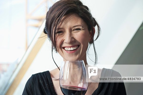 Mature woman with wine glass  smiling  portrait
