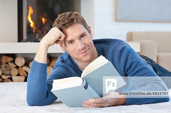 Mid adult man reading book at home  portrait