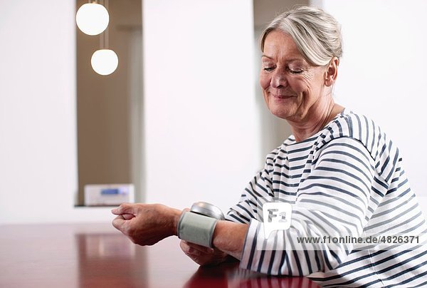 Ältere Frau  die den Blutdruck kontrolliert