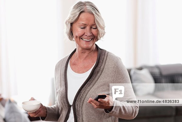 Senior woman using mobile and smiling