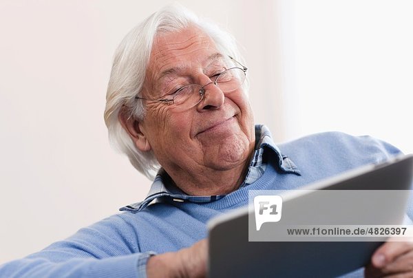 Senior man using laptop  smiling